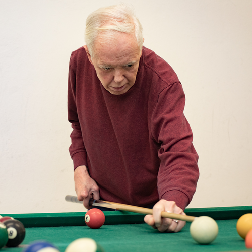 Eine leistungsberechtigte Person spielt Billiard.