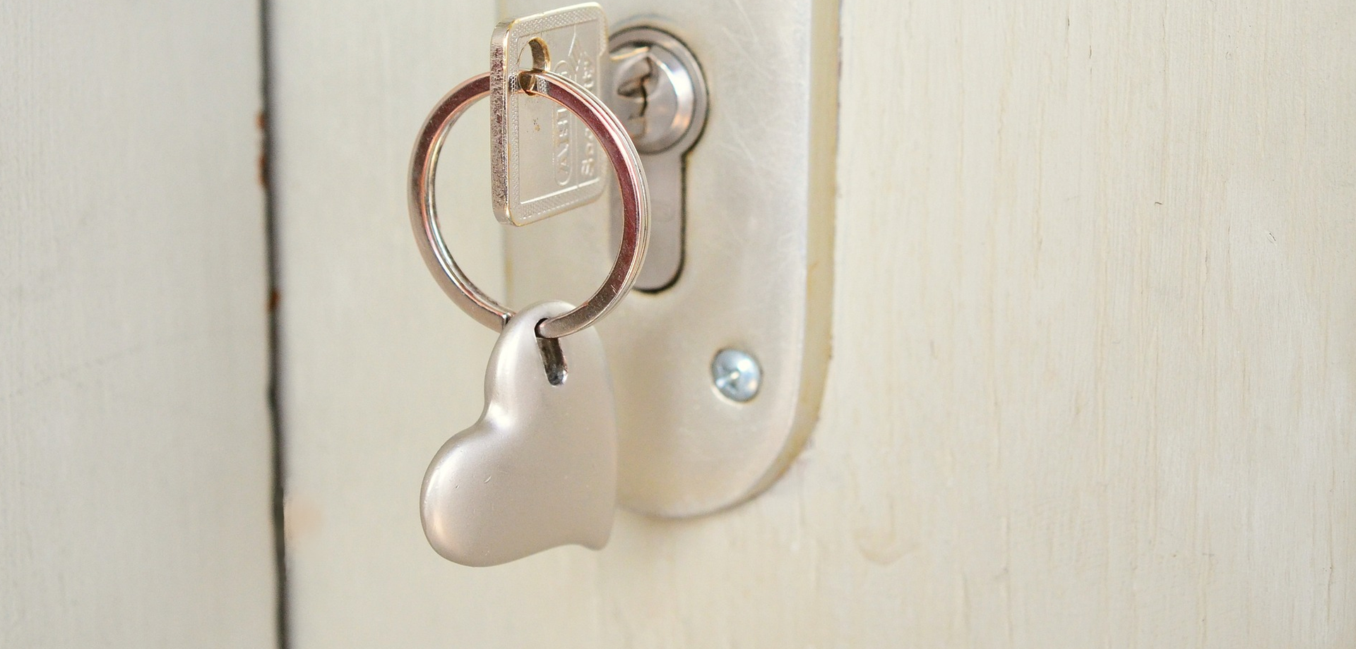 Ein Schlüssel mit Herzanhänger im Türschloss. Bild: pixabay